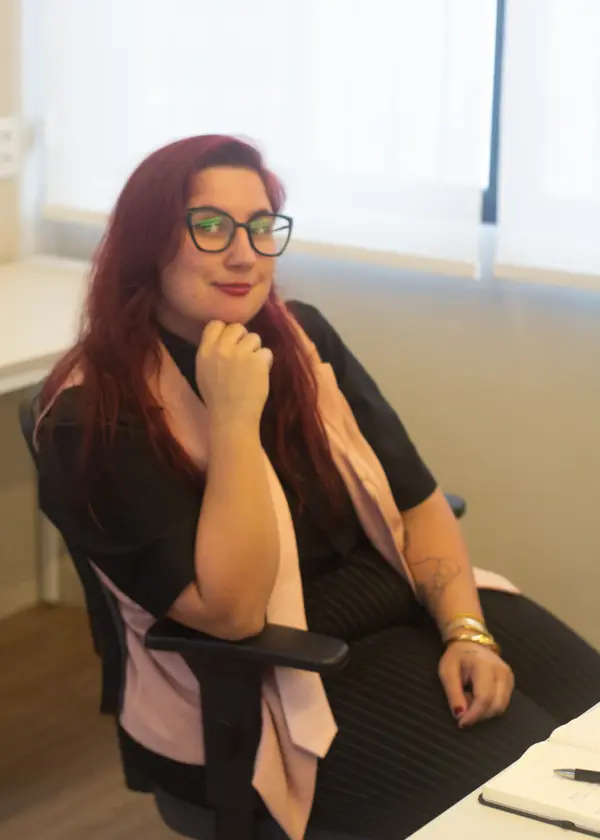 Maia sentada, sorrindo, durante um encontro de consultoria